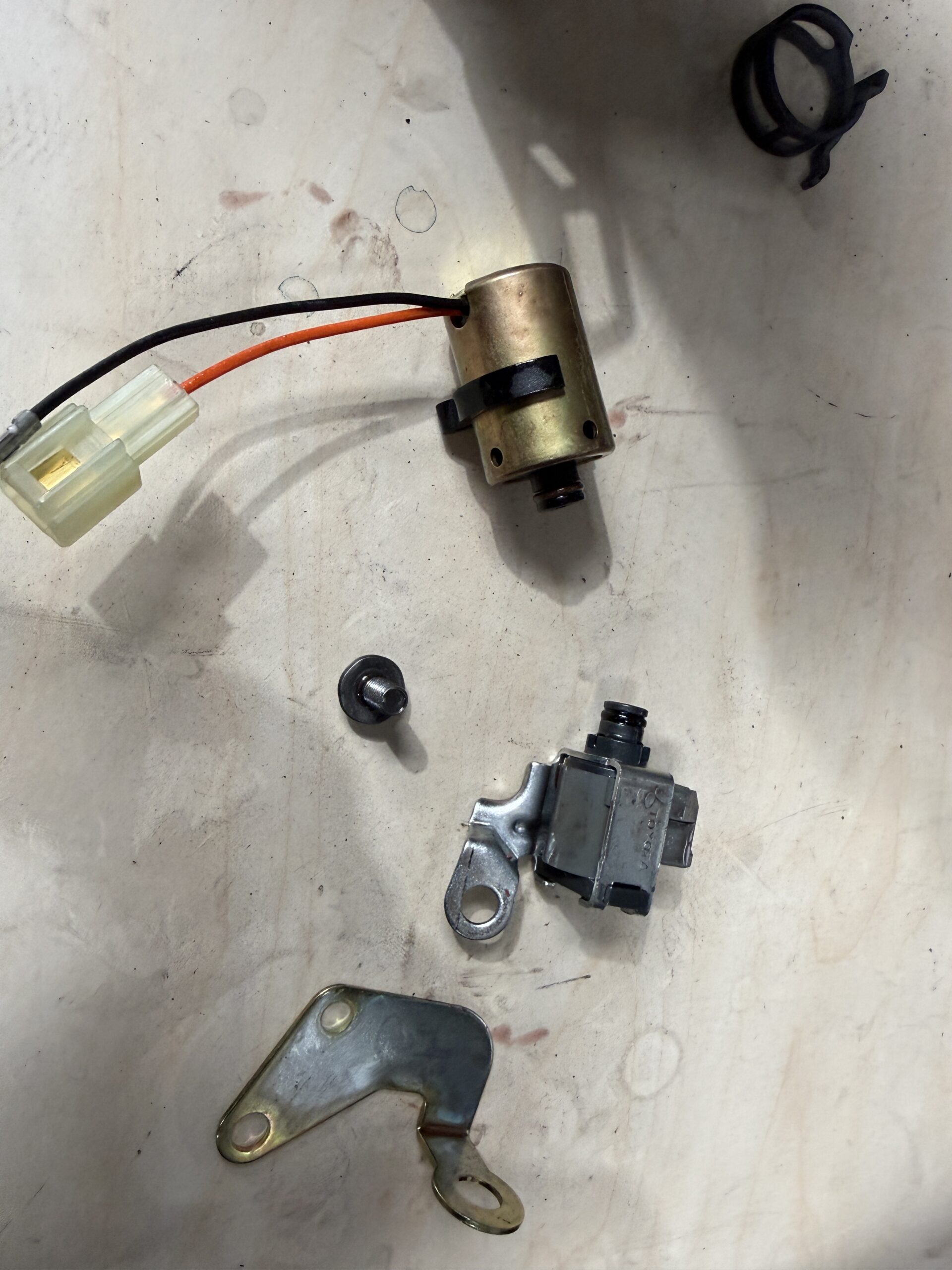 Close-up of two loose transmission components in the Luca Motors workshop.
