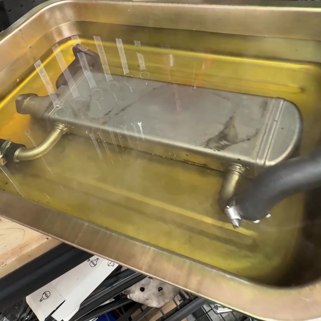 Volkswagen Amarok EGR cooler connected to hoses in a test tray on the workshop bench at Luca Motors in Alphington.